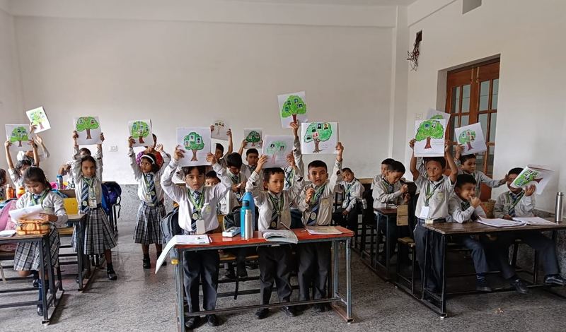 Young students showing their tree drawings in class