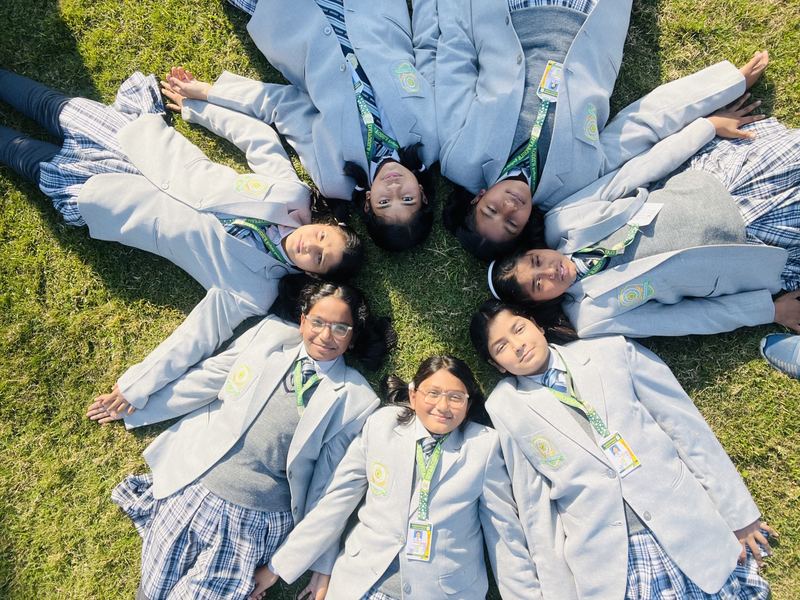 Students lying on the lawn in a star formation